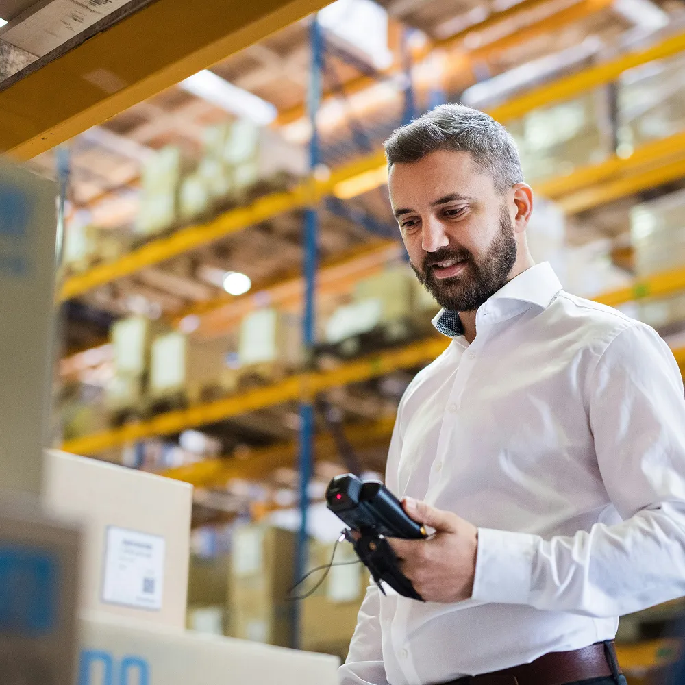 Ondernemer controleert voorraad met een barcodescanner in een magazijn