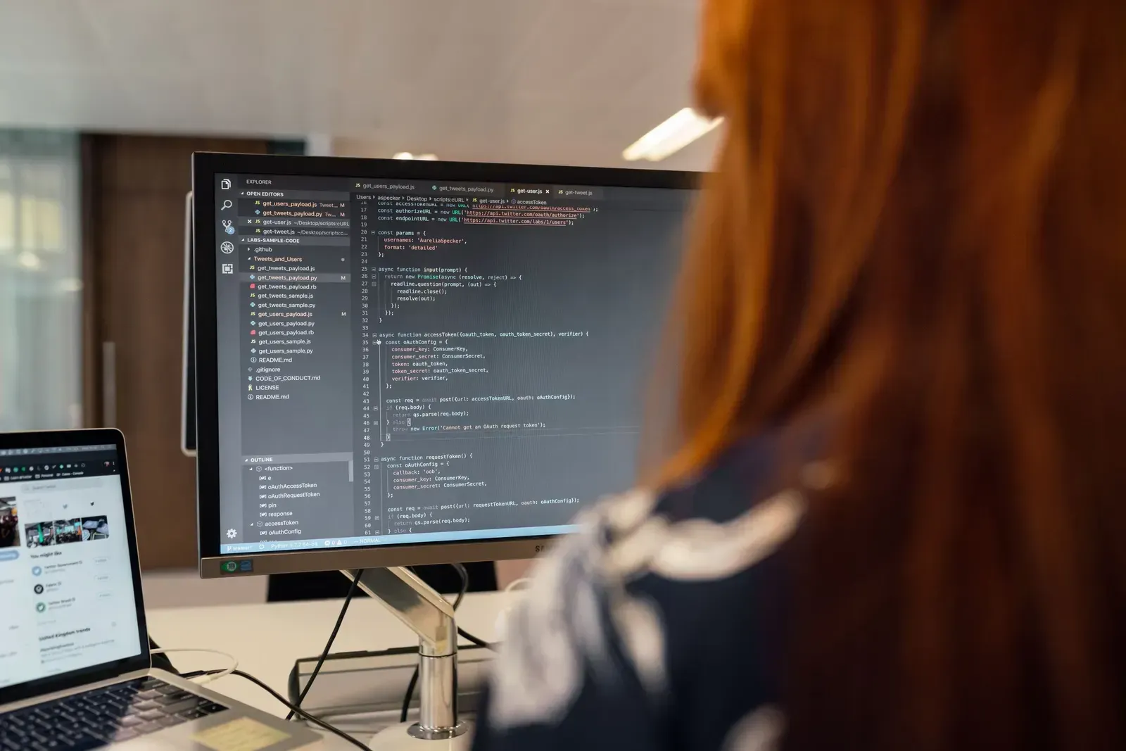 Ontwikkelaar werkt achter een beeldscherm met een geopende code-editor